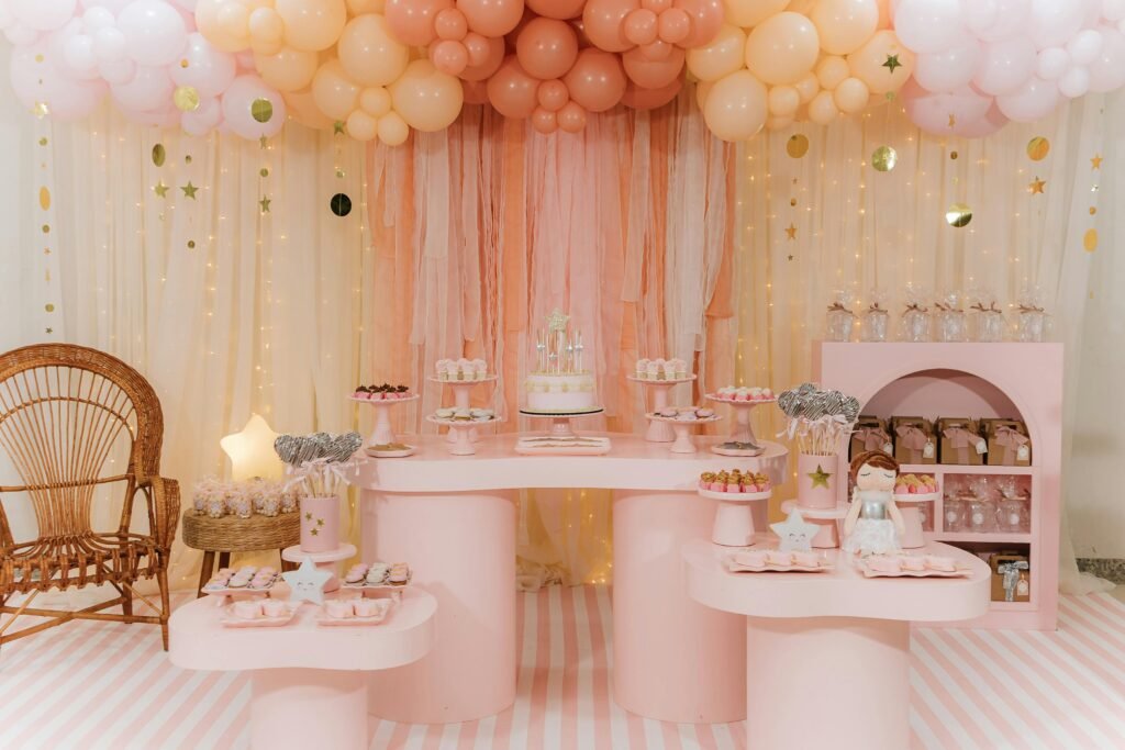 Charming pink and gold birthday party decoration with cake, balloons, and festive treats.